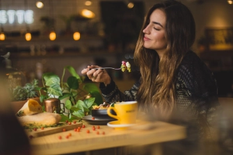 Dame som spiser mat på en restaurant hun fant ved hjelp av god søkemotor optimalisering fra et seo byrå